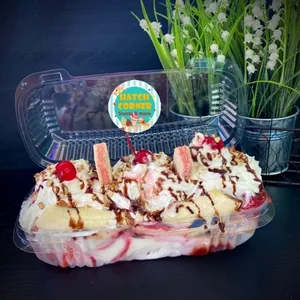 Banana split dessert with whipped cream, cherries, and chocolate drizzle from Hatch Corner Snacks & More in Hatch New Mexico